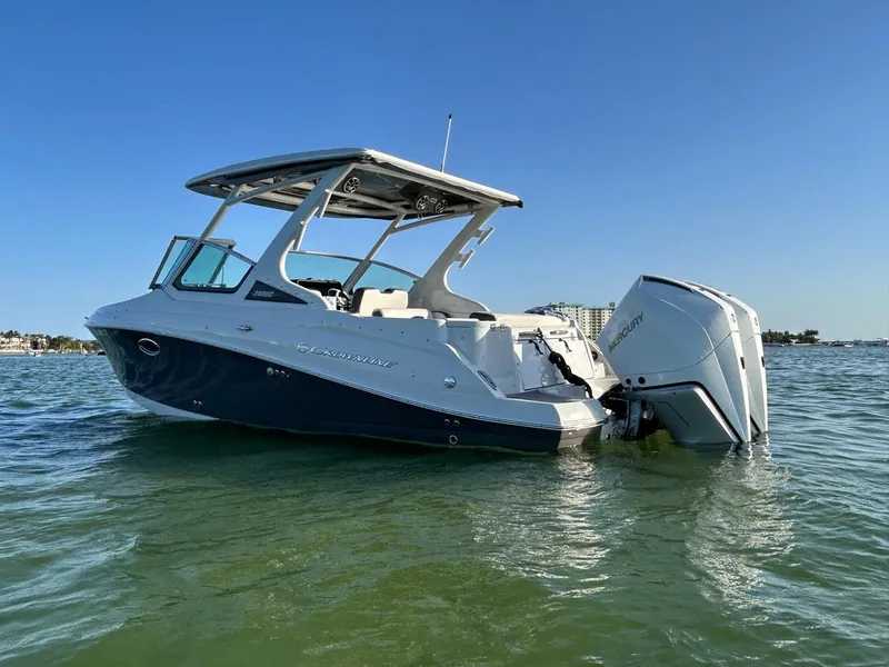 Slide: The Image of 2024 Crownline 260DC boat on water, clear sky background. - 2
