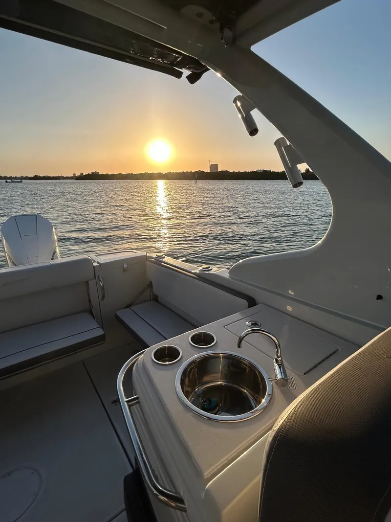 Slide: The Image of 2024 Crownline 260DC boat interior with sunset view over the water. - 7