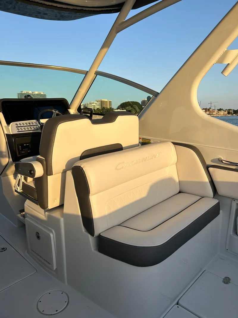 Slide: The Image of 2024 Crownline 260DC boat interior with plush seating and modern dashboard. - 8