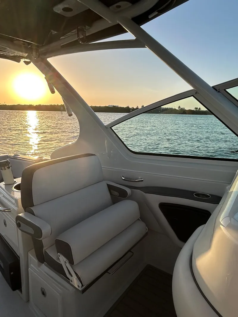 Slide: The Image of 2024 Crownline 260DC boat interior with sunset view over water. - 9