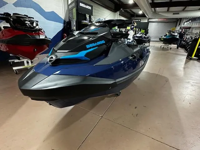 Slide: The Image of 2025 Sea-Doo GTX 230 jet ski in showroom, featuring sleek blue and black design. - 5