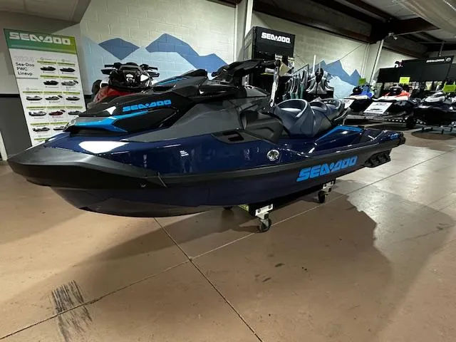 Slide: The Image of 2025 Sea-Doo GTX 230 jet ski in showroom, blue and black design, side view. - 6