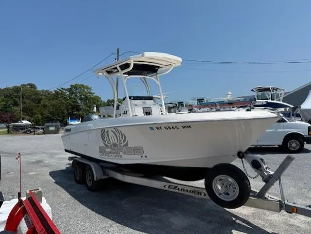 Slide: The Image of 2018 Wellcraft 222 Fisherman boat on trailer in sunny marina setting. - 2