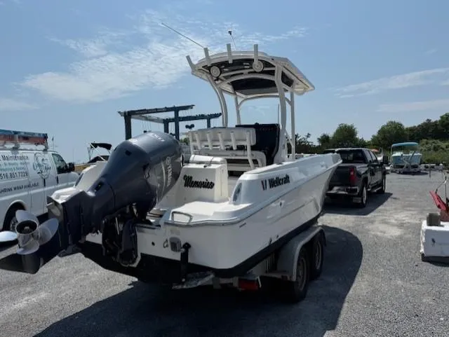 Slide: The Image of 2018 Wellcraft 222 Fisherman boat on trailer, parked outdoors under clear sky. - 3