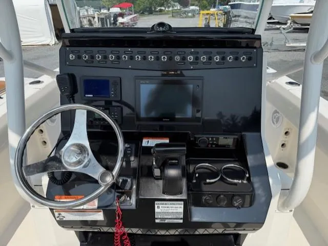 Slide: The Image of 2018 Wellcraft 222 Fisherman boat dashboard with steering wheel and electronic controls. - 6
