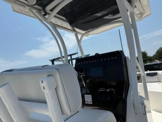 Slide: The Image of 2018 Wellcraft 222 Fisherman boat interior with white seating and control panel under a clear sky. - 8