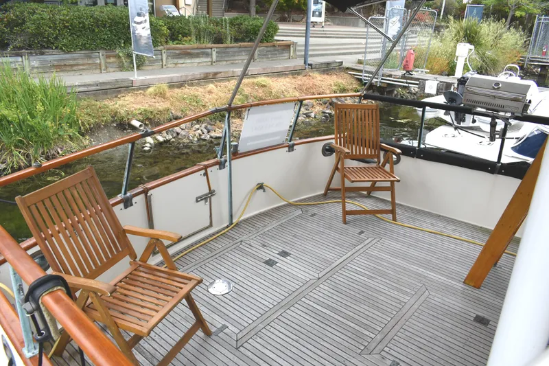 Slide: The Image of Deck of 1980 Grand Banks 42 Europa with wooden chairs and railing. - 6