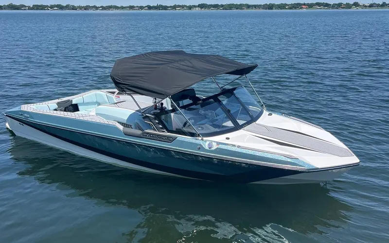 Slide: The Image of 2025 Nautique Ski boat with black canopy on a calm lake. - 12