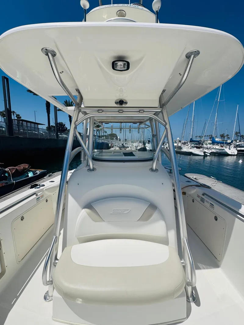 Slide: The Image of 2007 Boston Whaler 320 Outrage boat interior with seating and canopy, docked in marina. - 15