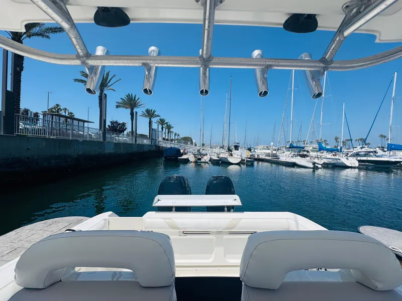 Slide: The Image of 2007 Boston Whaler 320 Outrage in marina, surrounded by sailboats and palm trees. - 24