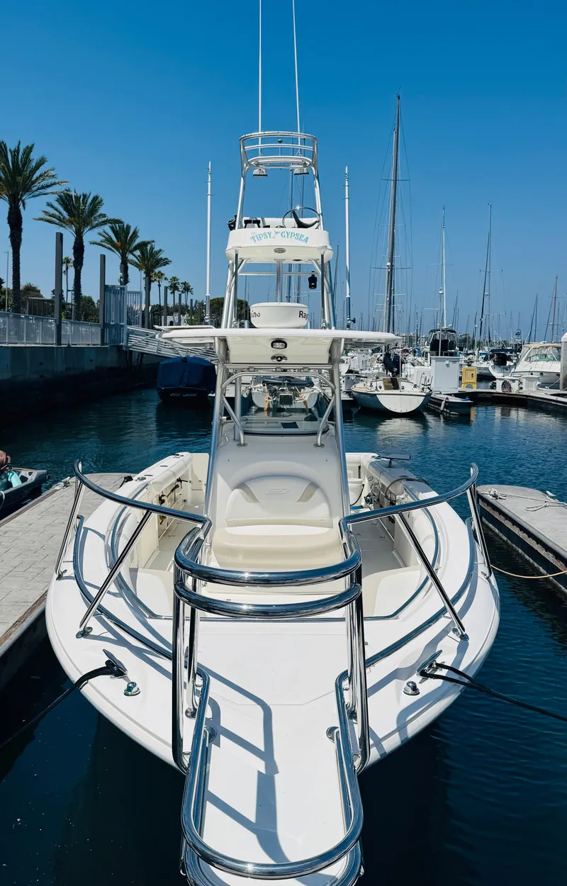 Slide: The Image of 2007 Boston Whaler 320 Outrage docked in a marina, surrounded by sailboats and palm trees. - 25