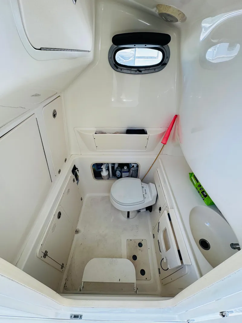 Slide: The Image of 2007 Boston Whaler 320 Outrage boat bathroom with toilet and storage compartments. - 29