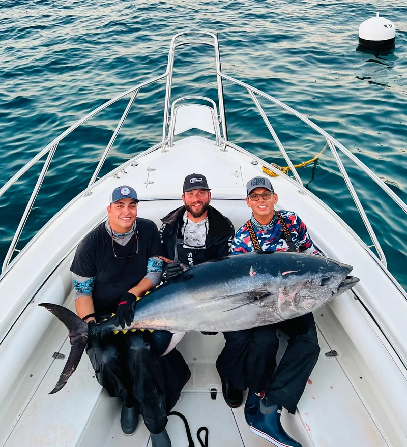 Slide: The Image of Three people on a 2007 Boston Whaler 320 Outrage with a large fish. - 31