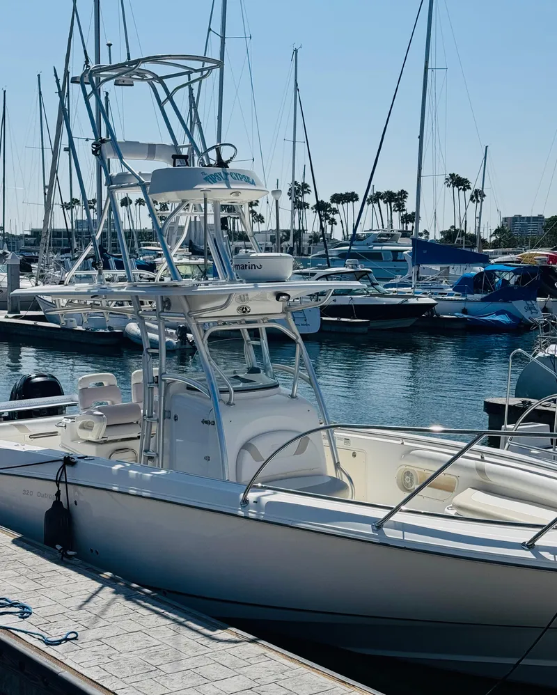 Slide: The Image of 2007 Boston Whaler 320 Outrage docked in a marina with sailboats in the background. - 6