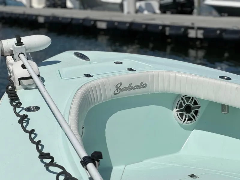 Slide: The Image of 2020 Sabalo 27 boat with mint green deck and white seating at a marina. - 7