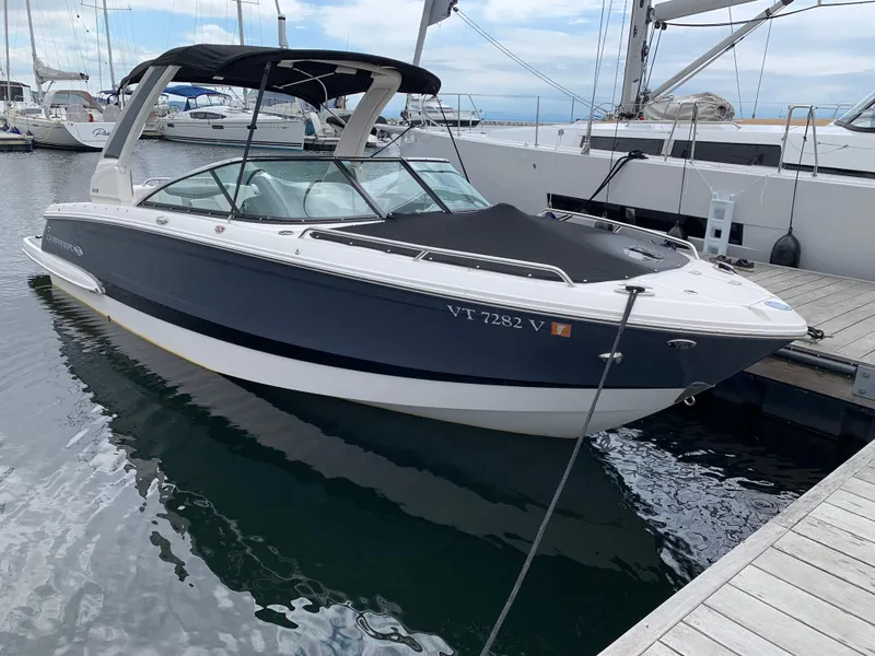 Slide: The Image of 2021 Chaparral 267 SSX boat docked at marina, featuring sleek design and black canopy. - 25