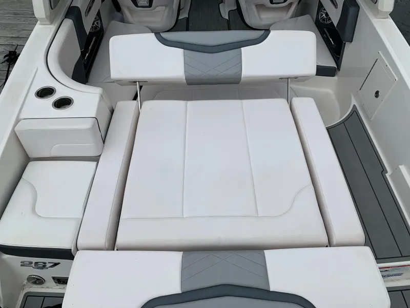 Slide: The Image of 2021 Chaparral 267 SSX boat interior with white cushioned seating and cup holders. - 30