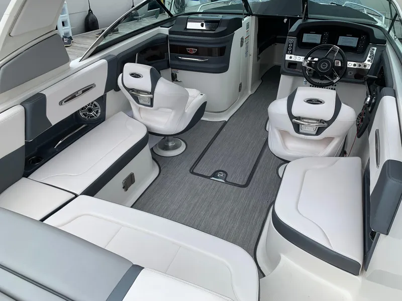 Slide: The Image of 2021 Chaparral 267 SSX boat interior with modern seating and sleek dashboard design. - 32