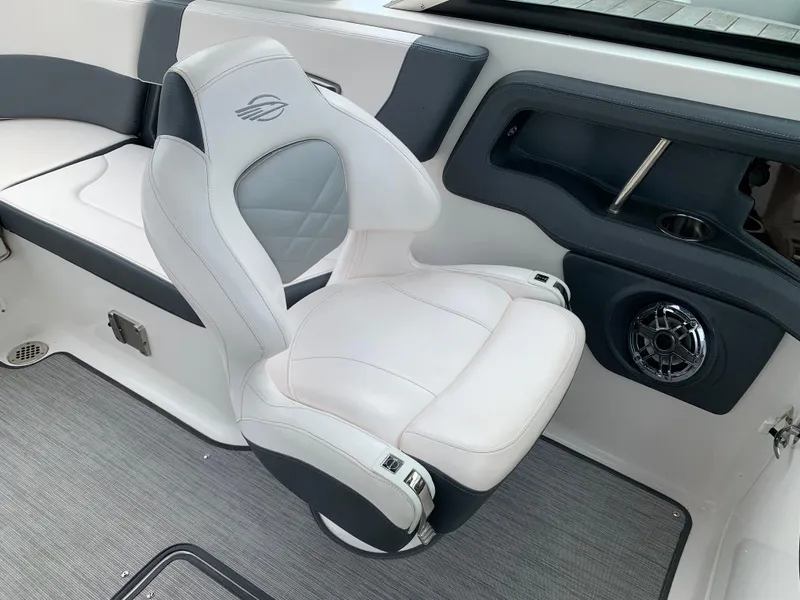 Slide: The Image of 2021 Chaparral 267 SSX boat interior with white and gray seating, speaker, and cup holder. - 40