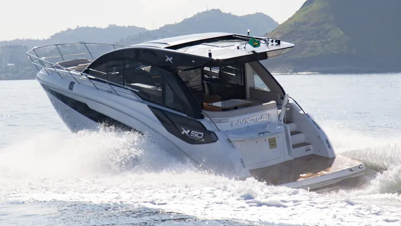 Slide: The Image of 2025 NX Boats NX50 Invictus HT cruising on water, showcasing sleek design and luxury features. - 10