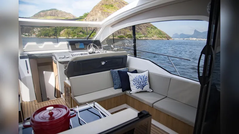 Slide: The Image of 2025 NX Boats NX50 Invictus HT interior with scenic ocean view and modern seating. - 13