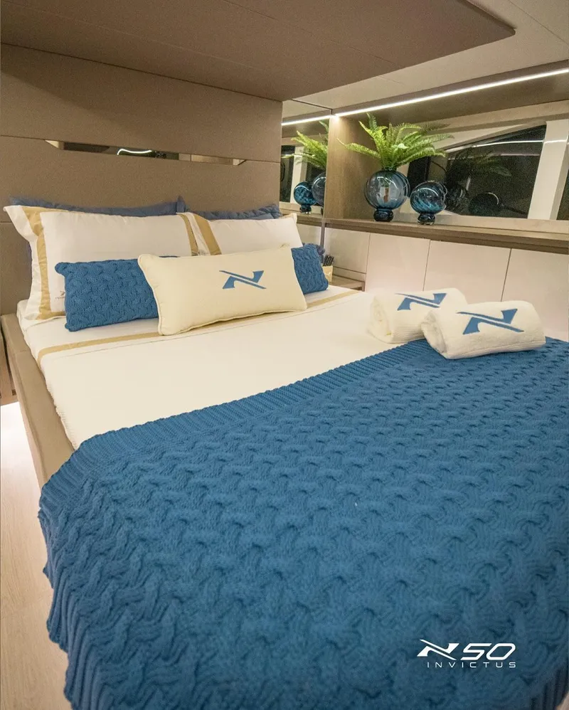 Slide: The Image of Luxurious bedroom interior of 2025 NX Boats NX 50 INVICTUS HT with blue accents. - 36