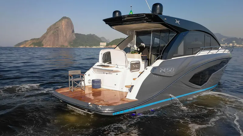 Slide: The Image of 2025 NX Boats NX50 Invictus HT yacht cruising near scenic coastal landscape. - 4