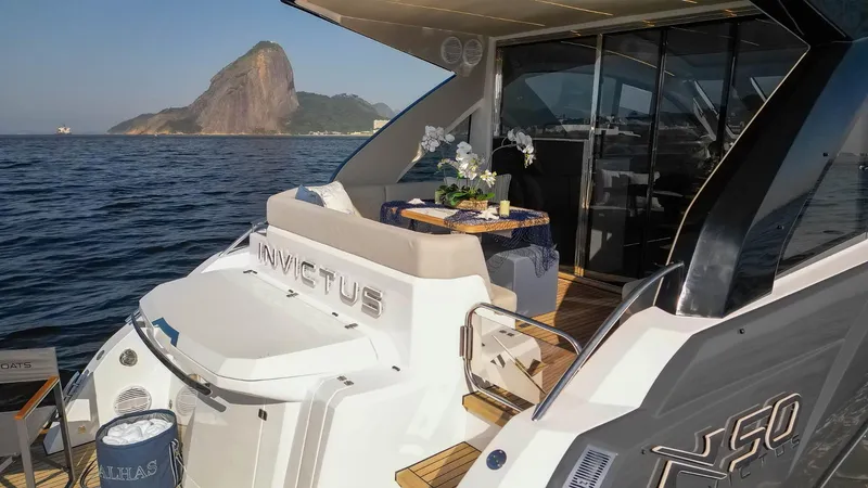 Slide: The Image of 2025 NX Boats NX50 Invictus HT yacht with elegant deck, ocean view, and scenic backdrop. - 5