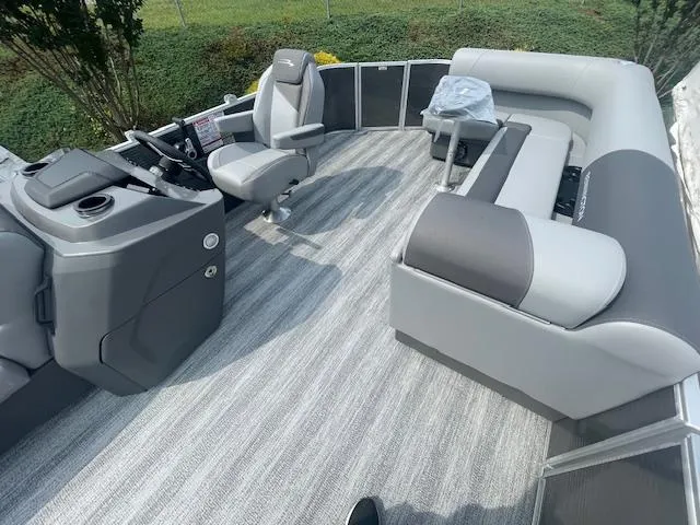 Slide: The Image of 2025 Bennington S21 Cruise pontoon boat interior with gray seating and modern helm. - 9