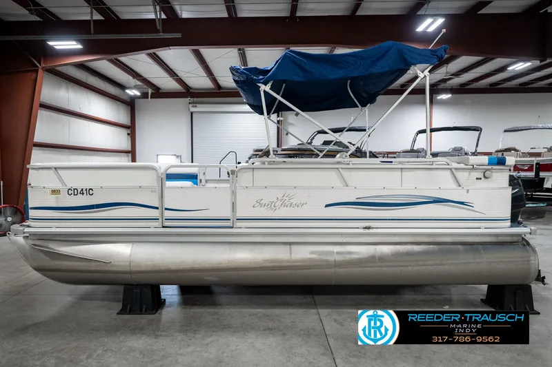 Slide: The Image of 2005 SunChaser 820 pontoon boat with blue canopy in indoor showroom. - 10