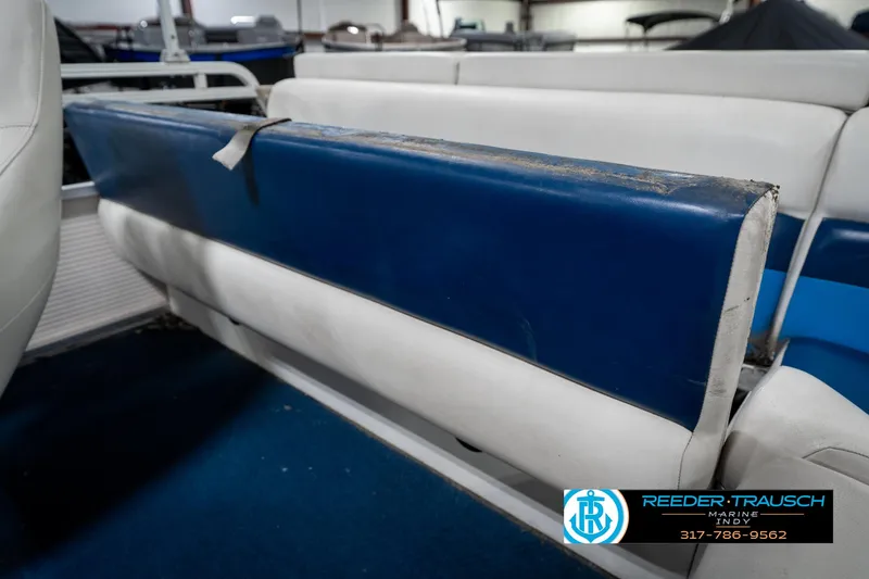Slide: The Image of 2005 SunChaser 820 boat interior with blue and white seating, showing wear. - 25