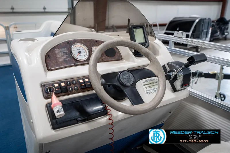 Slide: The Image of 2005 SunChaser 820 boat dashboard with steering wheel, controls, and gauges in a showroom. - 26
