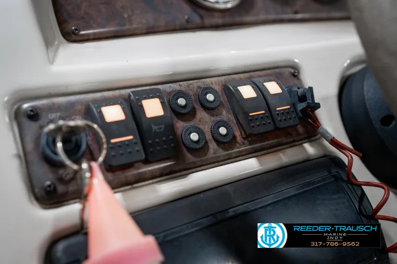Slide: The Image of Control panel of a 2005 SunChaser 820 boat with switches and keychain. - 30