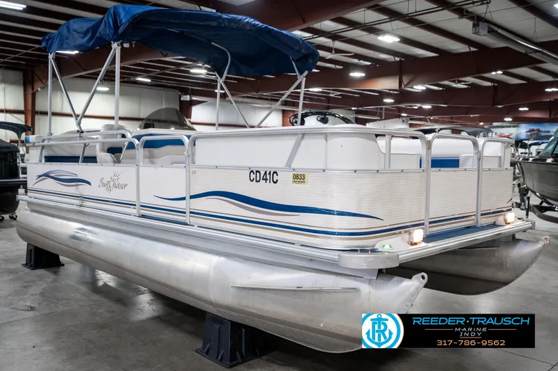 Slide: The Image of 2005 SunChaser 820 pontoon boat with blue canopy in indoor showroom. - 5