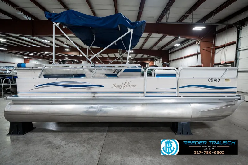 Slide: The Image of 2005 SunChaser 820 pontoon boat with blue canopy in indoor showroom. - 6