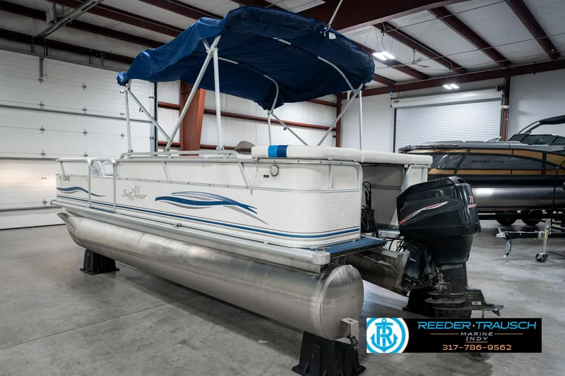 Slide: The Image of 2005 SunChaser 820 pontoon boat with blue canopy in indoor storage. - 9