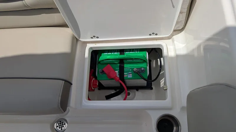 Slide: The Image of Battery compartment of a 2021 Key West 203 DFS boat, featuring a green battery. - 8