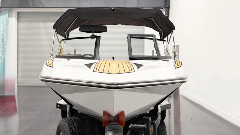 Slide: The Image of 2025 Nautique Ski boat with canopy, displayed indoors on a trailer. - 3