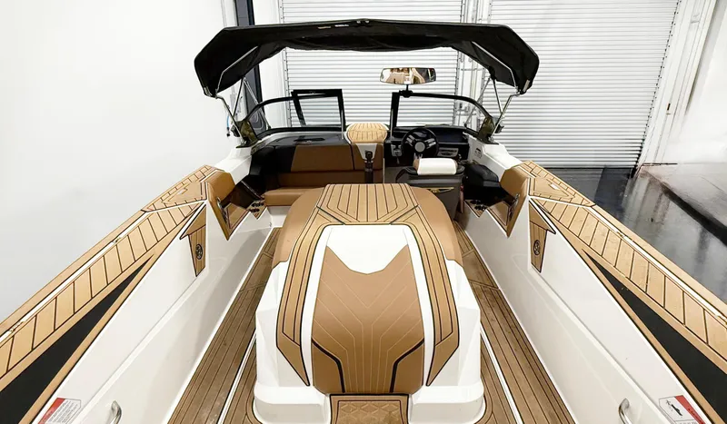 Slide: The Image of 2025 Nautique Ski boat interior with tan and white upholstery, sleek design, and modern dashboard. - 5
