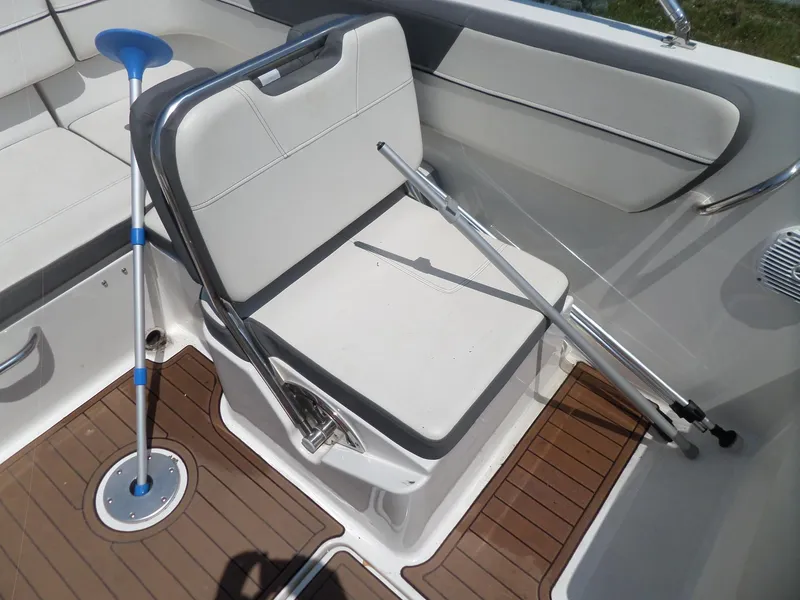 Slide: The Image of 2017 Bayliner VR6 Bowrider I/O interior with white seating and wooden flooring. - 18