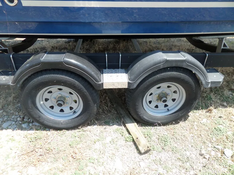 Slide: The Image of Trailer wheels of a 2017 Bayliner VR6 Bowrider I/O boat on grass. - 9