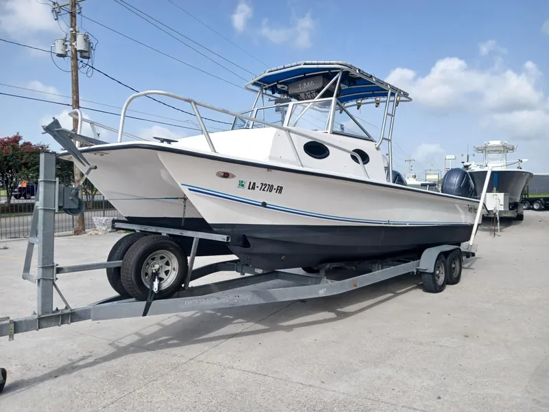 Slide: The Image of 2005 Twin Vee 26 Weekender boat on trailer, parked outdoors under blue sky. - 13