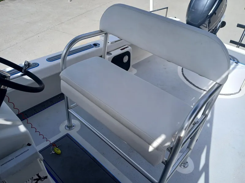 Slide: The Image of 2005 Twin Vee 26 Weekender boat interior with white seating and steering wheel. - 4