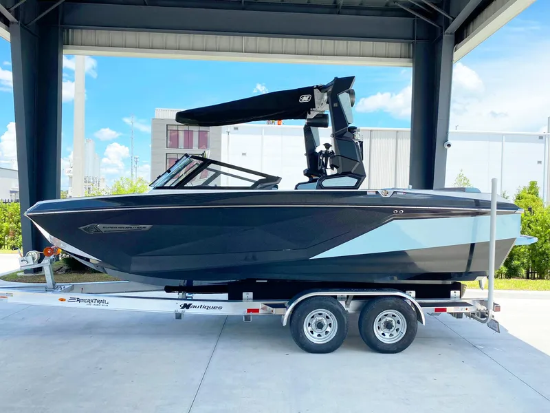 The Image of 2024 Nautique Super Air Nautique G21 boat on trailer under shelter. - 1