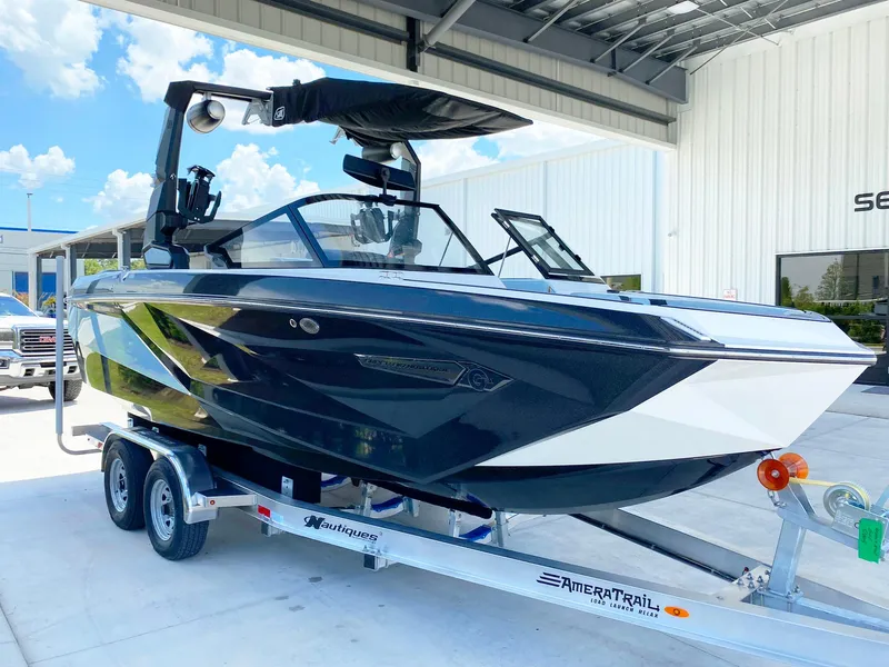 Slide: The Image of 2024 Nautique Super Air Nautique G21 boat on trailer, parked outdoors under a canopy. - 5