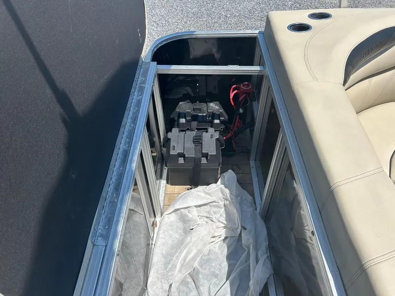 Slide: The Image of 2018 Sylvan Mirage 8522 Cruise boat battery compartment with beige seating and cup holders. - 17
