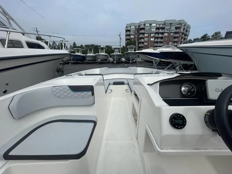 Slide: The Image of 2022 Bayliner 170 Element boat interior with dashboard and seating, docked among other boats. - 2