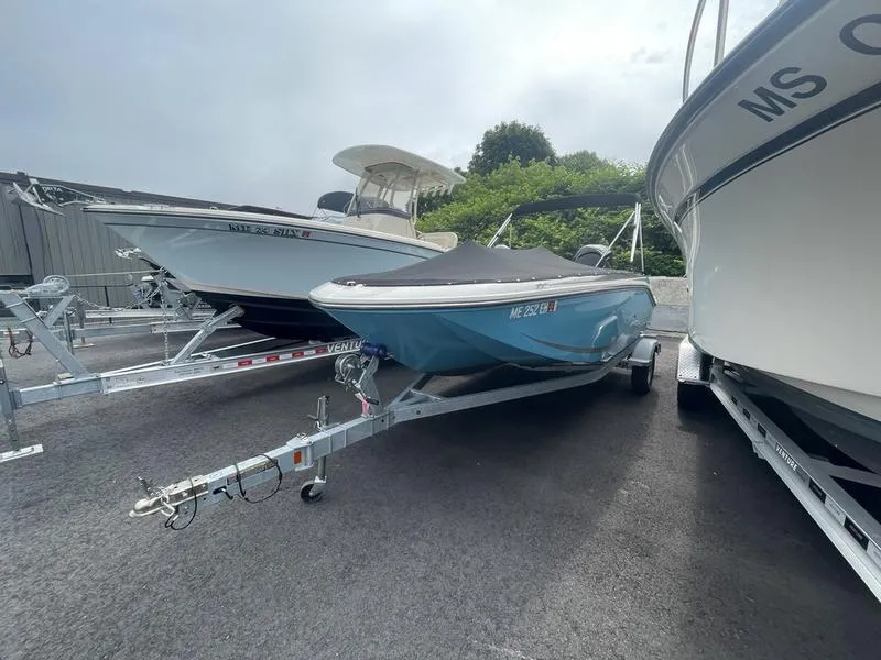 Slide: The Image of 2022 Bayliner 170 Element boat on trailer, parked between other boats in a lot. - 4