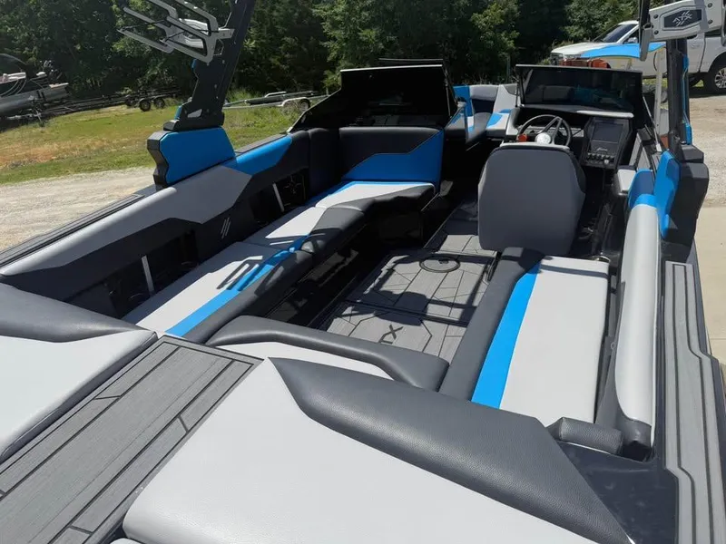 Slide: The Image of 2023 ATX Surf Boats 24 Type-S interior with blue and gray seating, steering wheel, and open layout. - 7