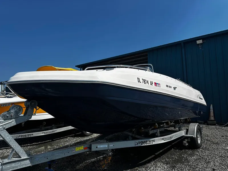 The Image of 2024 Godfrey 231 Center Console boat on trailer, parked outdoors under clear blue sky. - 0